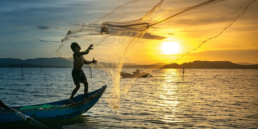 An image of a person holding a perch fish with dark vertical stripes, showcasing the catch and release aspect of Game Fishing in Paro