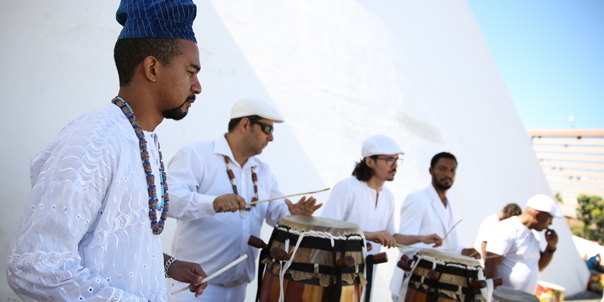 A group of men playing drums and singing in their traditional attire - traditional Maldivian drumming and dance