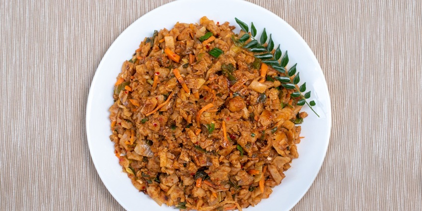 An image of delicious Kottu on a white plate, a flavourful Sri Lankan street food