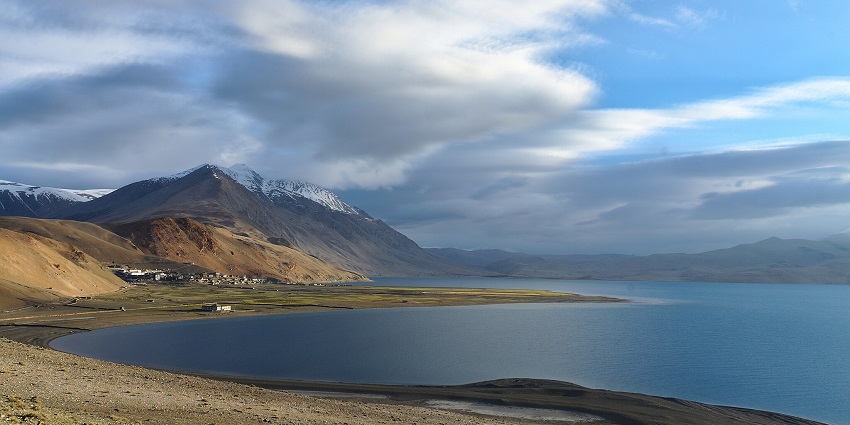 Tso Moriri Lake with a sandy shoreline, sandy mountains and peaks covered in snow