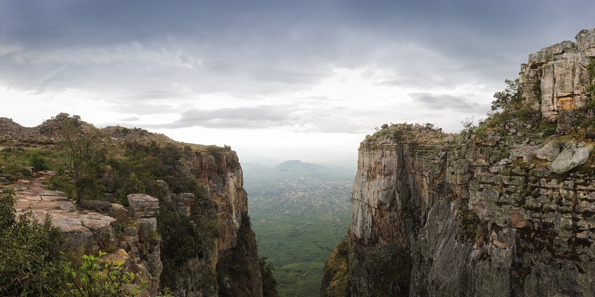 A picture of a canyon in Angola with rocky hills and lush greenery all around