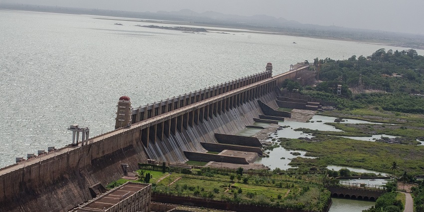A vast reservoir near Hampi, with gushing water showcasing the dam’s massive structure.