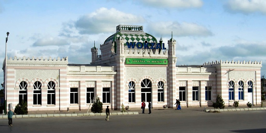 Turkmenbashi railway station with ornate architecture, striped exterior, and green dome