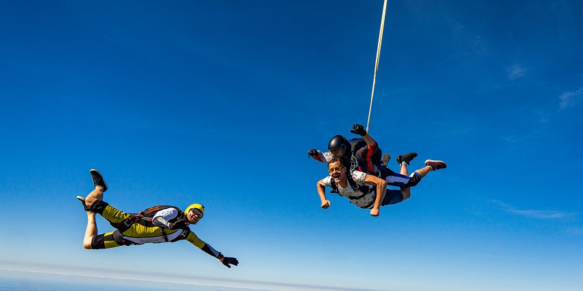 A stunning view of multiple sky divers above in the blue sky before landing in Europe