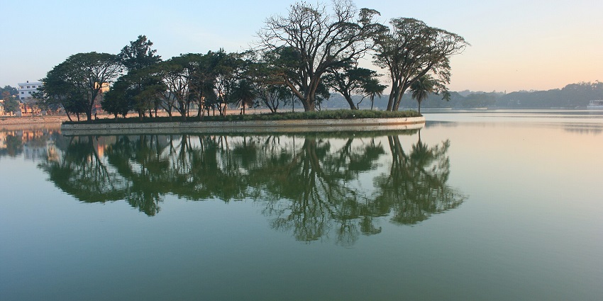 Island in the middle of Ulsoor lake, reflecting the green trees on the still waterbody