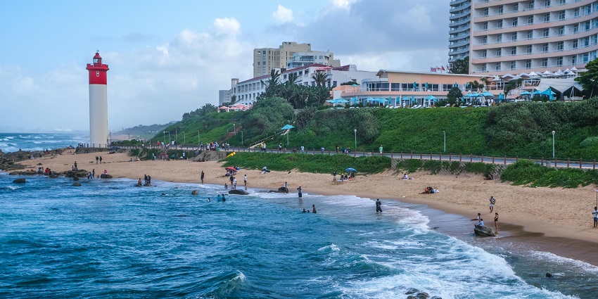 Scenic view of Umhlanga Lighthouse with visitors exploring what to wear at Durban beach.