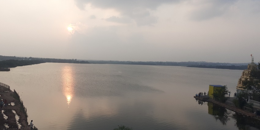 Sunset view on Unkal Lake, golden color reflected on the calm water surrounded by greenery