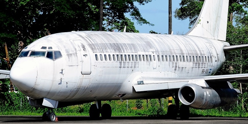 A Boeing 737 is resting on the runway, surrounded by greenery in one of the airports in Honduras.