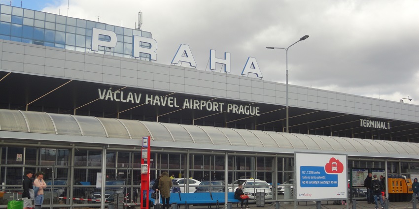 Prague Airport is bustling with aeroplanes, passengers, and vehicles moving around
