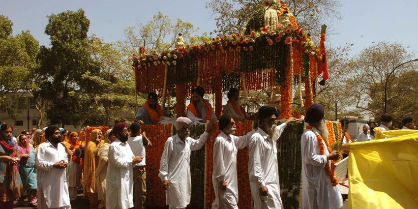 An image of Sikhs in vibrant attire celebrating Baisakhi with Nagar Kirtan and Bhangra dances