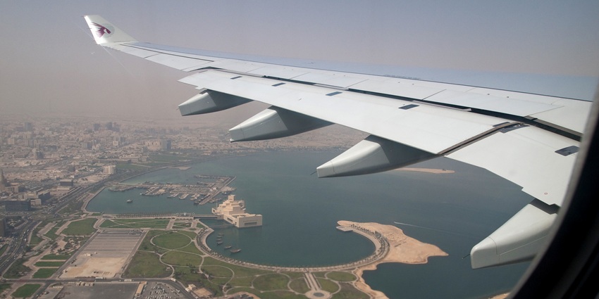 The wing of an aircraft spread above the vastness of the ocean as seen from its window.