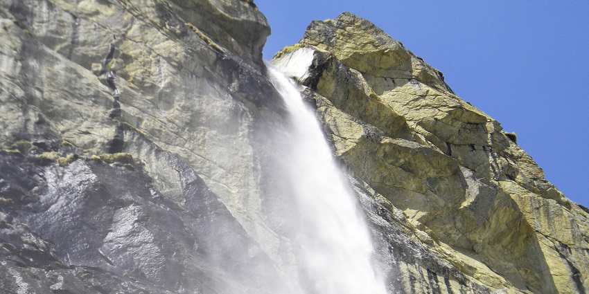 A waterfall flowing down rocky cliffs, one of the best place to see near Badrinath