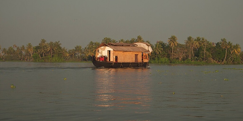 An image of Vembanad Lake, a famous fresh water lake in India, with lush green surrounding