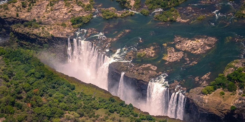 Witness the awe-inspiring " The Smoke That Thunders" as the Zambezi River crashes into the gorge.