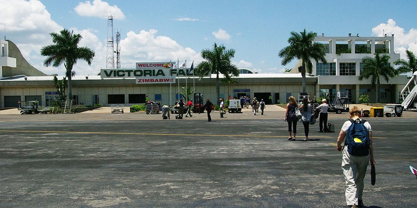Victoria Falls Airport entrance with a welcome board and passengers entering the terminal