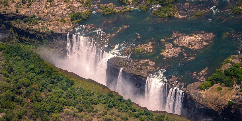 A powerful waterfall creates a misty spray visible from miles away.