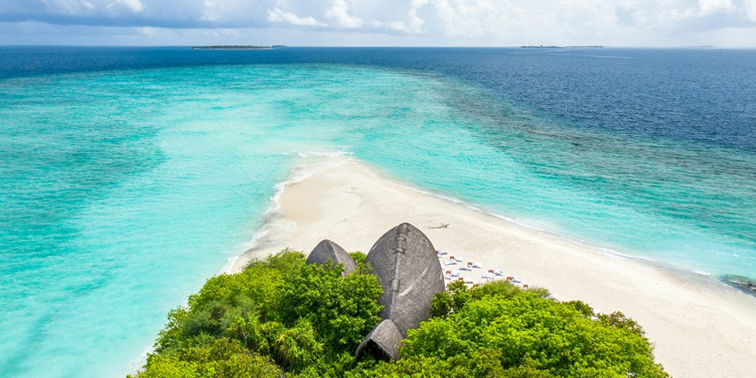 A serene view of the Villingili Island featuring golden sands and shimmering waters.