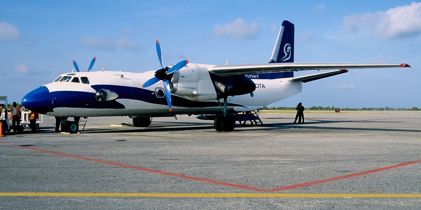 Blue and white aeroplane of Aerogaviota Airlines with people standing in the front