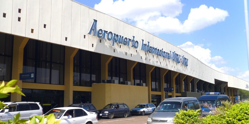 Cars are moving outside Viru Viru International Airport while people are arriving.