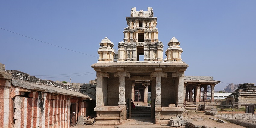 A distant view shows the towering gopuram of an ancient Virupaksha Temple in Hampi, as described in this Hampi travel guide.