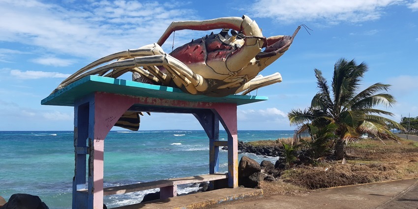 Colourful lobster-shaped bus shelter on Corn Island, showcasing vibrant coastal art and culture.