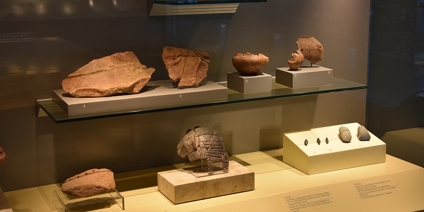 Different shaped archaeological findings displayed in a glass box Athens International Airport