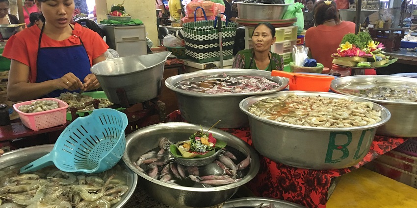 Busy scene of street vendors selling fresh produce at Badung Market.