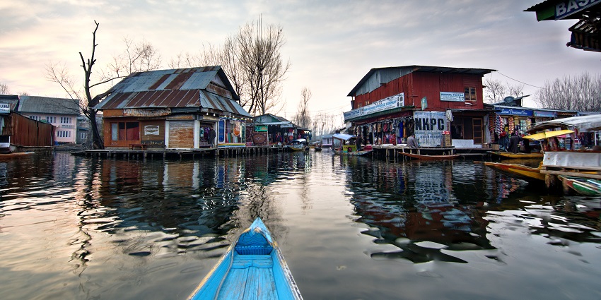 Floating market on Dal Lake with multiple different shops and dried trees with no leaves
