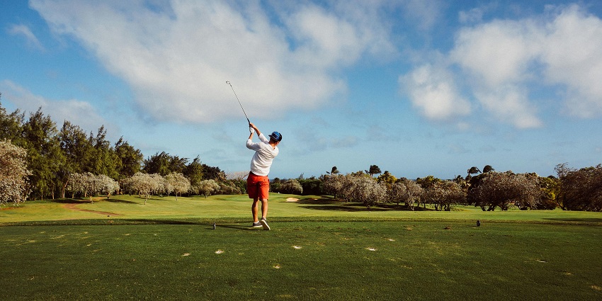 Picture of a man playing golf at Golf & Resort, featuring a beautiful golf course surrounded by mountains.