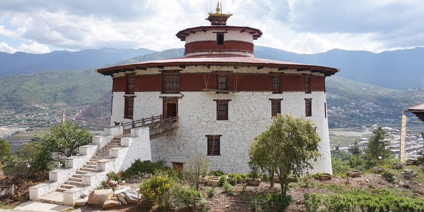 A frontal view of a traditional building in Paro, Bhutan, surrounded by lush expanses