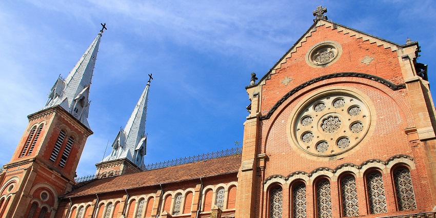Facade of Notre Dame Cathedral Basilica with its distinctive red bricks and twin bell towers.