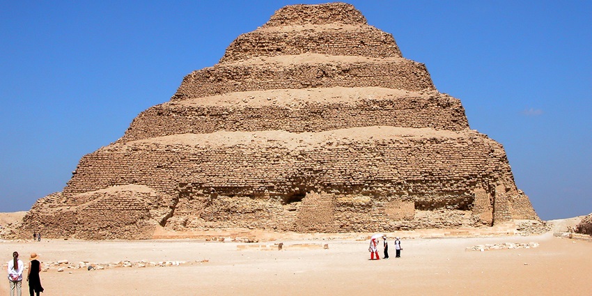 Image of tourists gazing at the iconic Step Pyramid of Djoser at Saqqara Necropolis.
