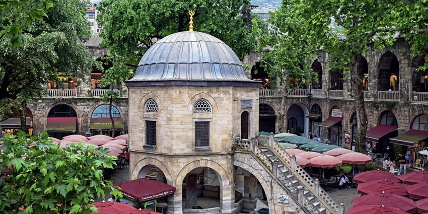 An image of Koza Han in Bursa, Turkey, showcasing its historic courtyard and vibrant marketplace.