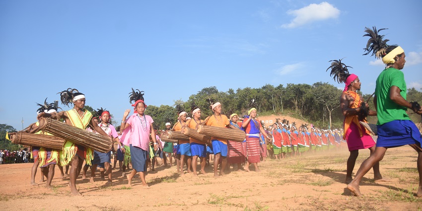 An image of a traditional cultural dance with participants in colorful attire and headdresses, holding musical instruments, during the Wangala festival of Meghalaya.