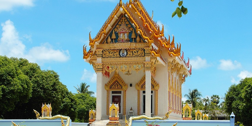 Wat Khunaram’s traditional Thai architecture with intricate golden details and red roofs.