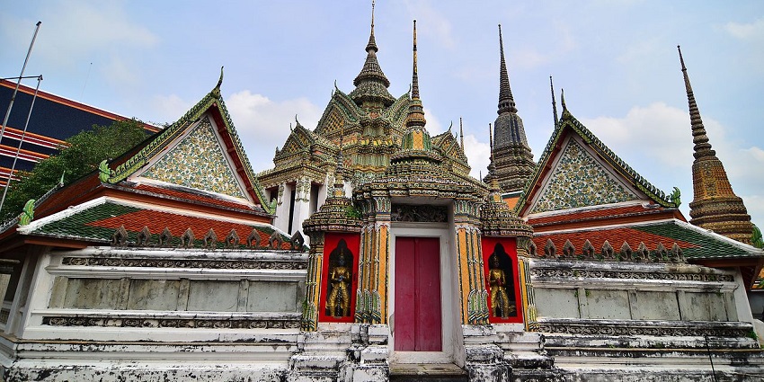 A serene view of the Reclining Buddha statue at Wat Pho, with intricate gold detailing and peaceful surroundings.