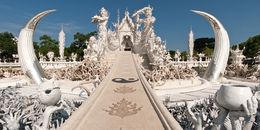 The stunning White Temple (Wat Rong Khun) in Chiang Rai, Thailand, with intricate white architecture.