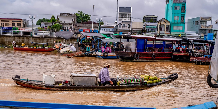 Scenic view of Wat Sai with boats, local vendors, and colourful goods on display.