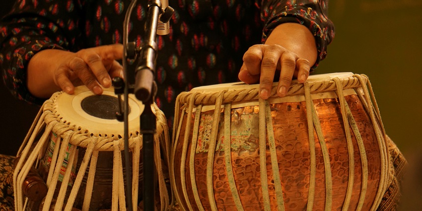 People sitting around the musical instruments for bhajan with mics and green wires