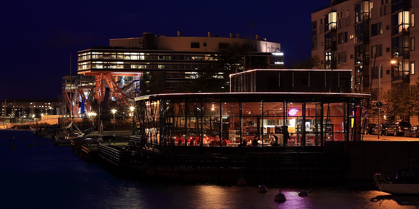 Night view of a restaurant in Finland filled with customers enjoying their food.