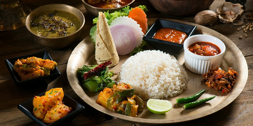 Image of nepali food in Nepali - pieces with steam coming out of them and served in a small white bowl