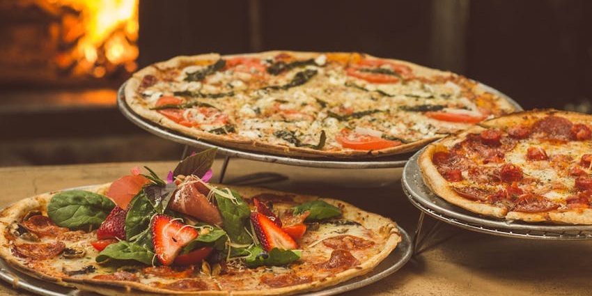 The close-up shot of a freshly baked pizza on a table displaying various toppings.