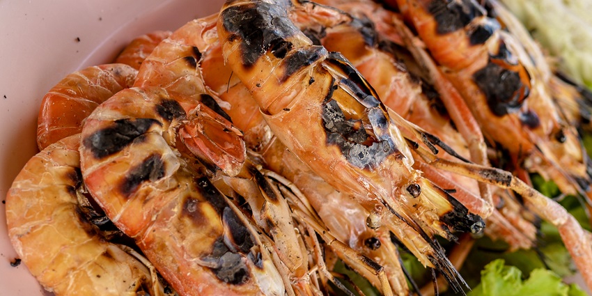 Tasty grilled shrimps at Lamai Beach, Koh Samui, garnished with herbs and served hot.