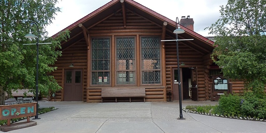 Lake Louise Heritage Railway Station restaurant surrounded by trees and a signage