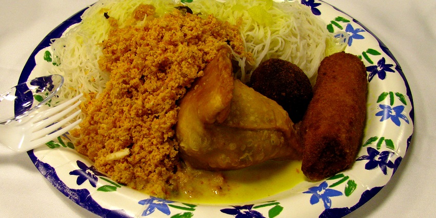 the white stuff is "string hoppers", made of rice flour. the orangish thing is "pol sambol", a hot coconut salady thing