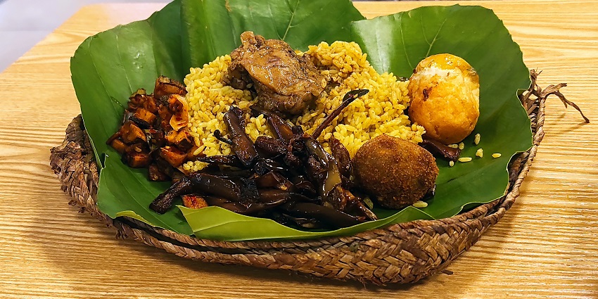 Traditional meal served on banana leaves, featuring rice, eggs, chicken, and veggies