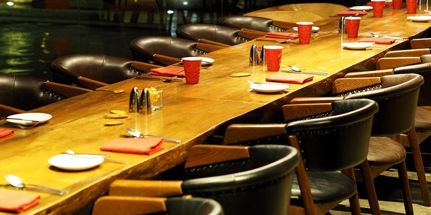 An image showing a dining setup in a restaurant featuring a table with menus and glassware.