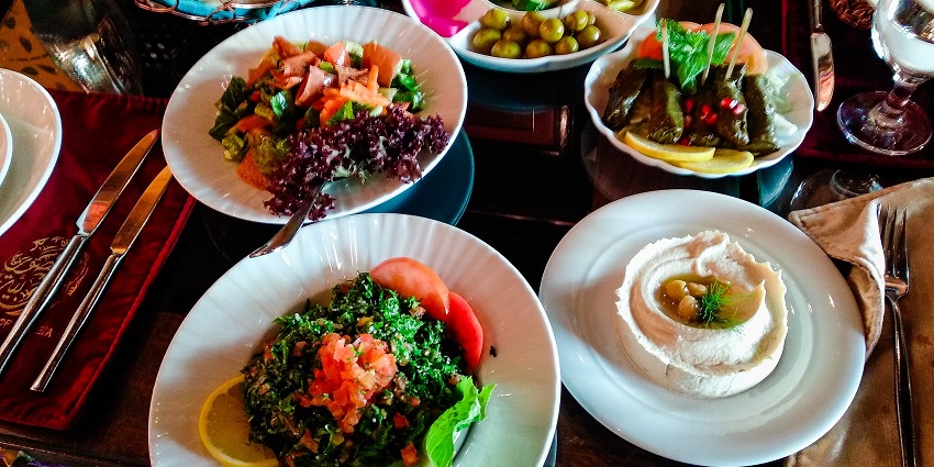 Traditional Middle Eastern mezze spread featuring tabbouleh, hummus, stuffed grape leaves
