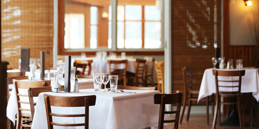 An image of an elegant restaurant featuring wooden chairs, resembling the places to eat around