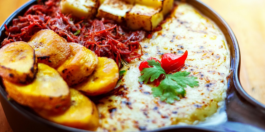 A plate of food including fried Cassava, rice, and other vegetable sides and garnishing